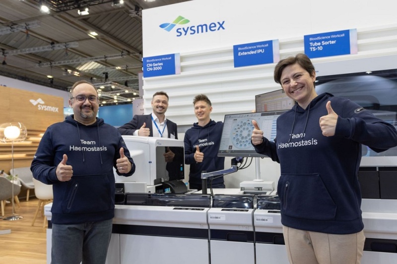 Group photo of Sysmex EMEA's hemostasis team in front of the exhibition booth